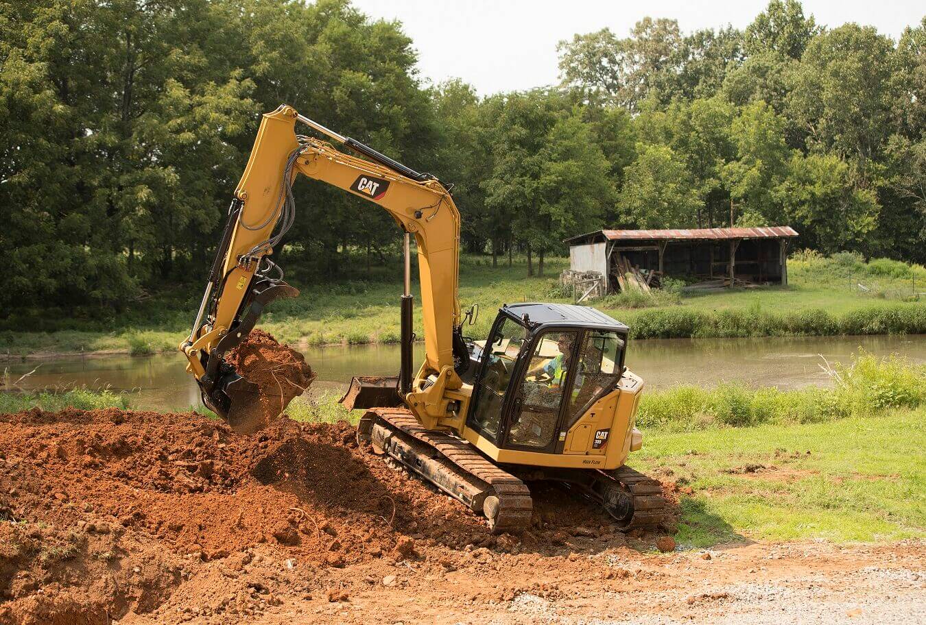 Escavatore Caterpillar a noleggio CGTE durante lavoro di scavo per opere di cura del verde CGTE Vermietung: