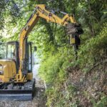 Noleggio escavatore cat con fresaceppi spaccalegna per lavori di manutenzione ciglio stradale forestale